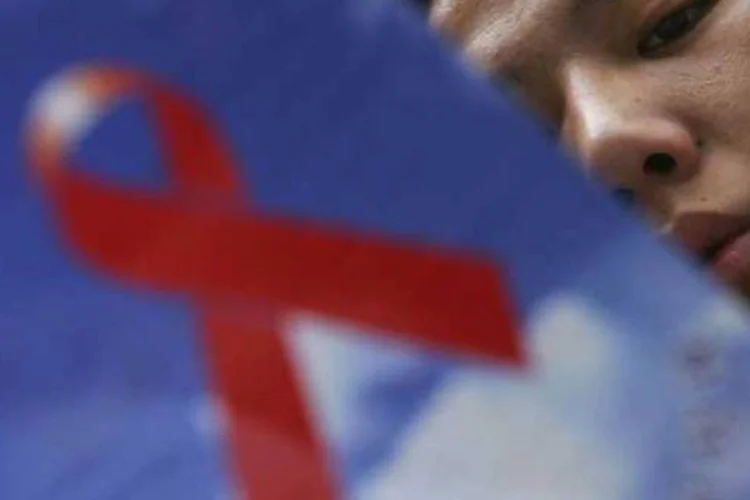 Chinês lê panfleto com informações sobre a Aids (Guang Niu/Getty Images)