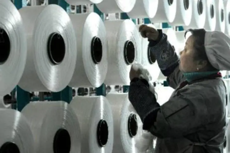 Trabalhadora chinesa trabalha em fábrica de cobertores para exportação (AFP)