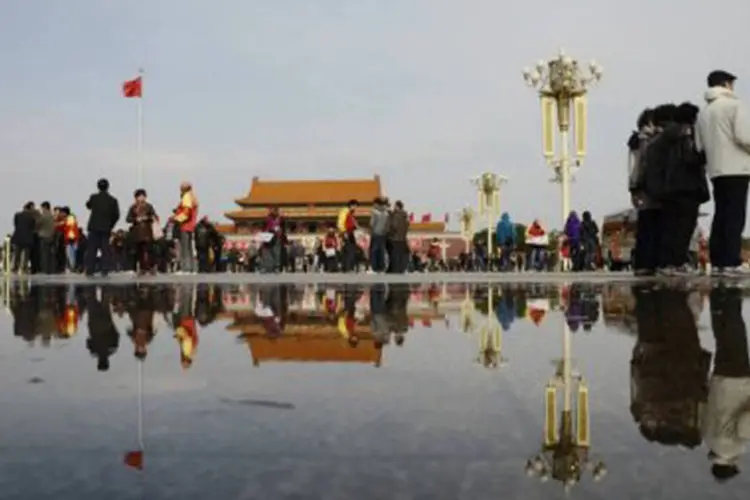 Visitantes andam pela praça Tiananmen, em Pequim, durante o XVIII Congresso do PCC em 5 de novembro
 (Wang Zhao/AFP)