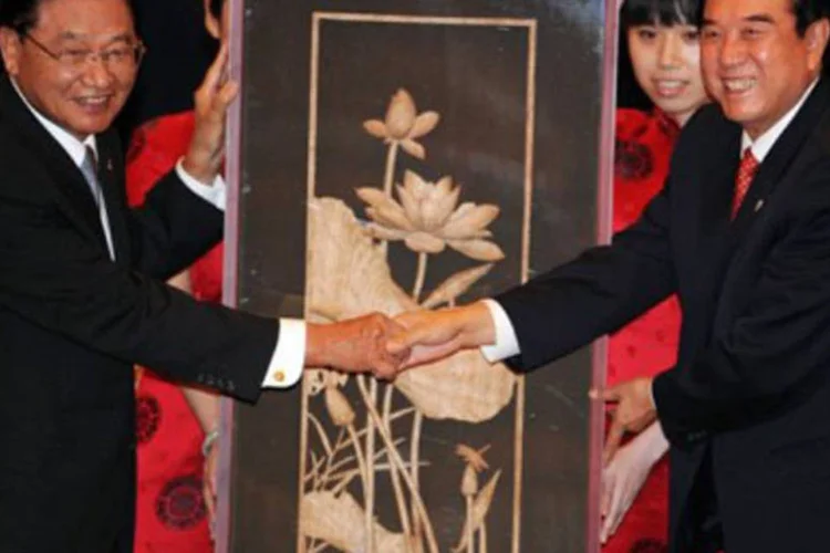 Representantes de China e Taiwan se cumprimentam após o fechamento do acordo, quebrando um período de 60 anos de conflitos diplomáticos (.)