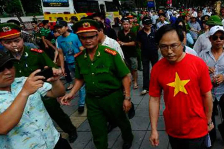 
	Policiais diante da embaixada da China em Han&oacute;i: dois navios chineses chegaram nesta segunda-feira &agrave; prov&iacute;ncia vietnamita de Ha Tinh
 (Hoang Dinh Nam)