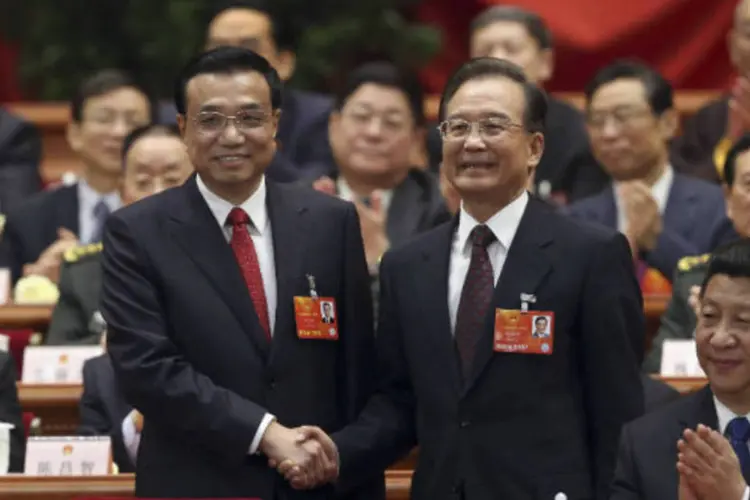 O recém-eleito primeiro-ministro da China, Li Keqiang (E), aperta a mão de Wen Jiabao durante reunião plenária da Assembleia Popular Nacional (APN), em Pequim (REUTERS / China Daily)