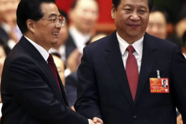 Hu Jintao (E) aperta a mão do presidente recém-eleito da China, Xi Jinping, durante a reunião plenária da Assembleia Popular Nacional (APN), em Pequim (REUTERS / China Daily)