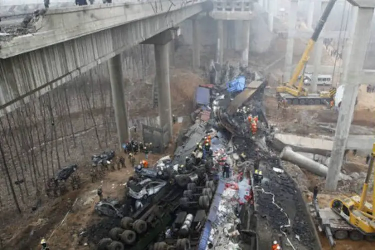 Equipes de socorro no local da explosão do caminhão que derrubou uma ponte e matou 26 pessoas em Henan, na China (AFP)