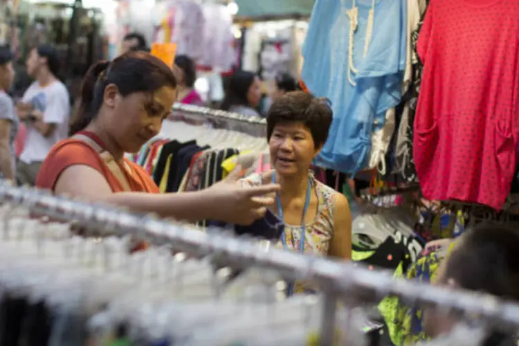 
	Consumidora chinesa escolhe roupa em loja: pa&iacute;s vai incentivar empr&eacute;stimos a pequenas empresas
 (Jerome Favre/Bloomberg)