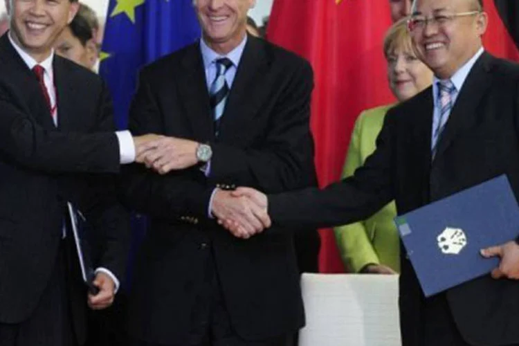 Aperto de mãos triplo entre o patrão da Airbus, Tom Enders (ao centro), Li Hai e Li Xiaopeng marca a assinatura do acordo
 (John Macdougall/AFP)