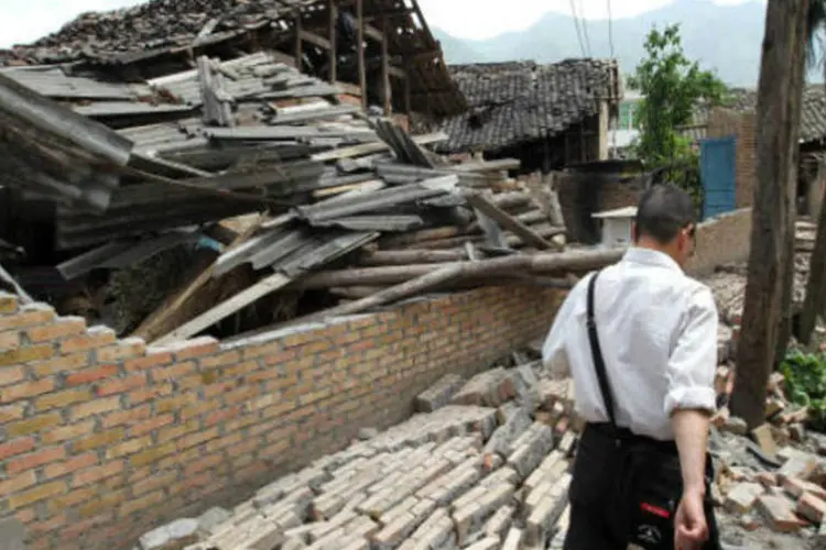 
	Um homem caminha pela prov&iacute;ncia de Sichuan, na China, ap&oacute;s um terremoto
 (ChinaFotoPress/Getty Images)