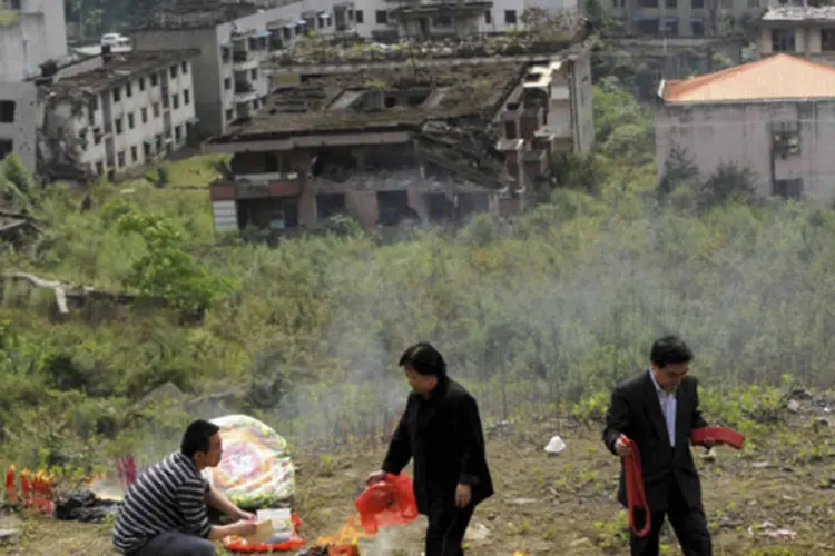 Pessoas queimam oferendas para parentes que morreram no terremoto de 2008, em Beichuan, em 11 de maio de 2013 (Reuters/Stringer)