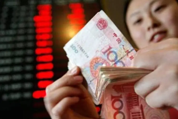 Chinesa conta notas de iuane (Teh Eng Koon/Reuters)