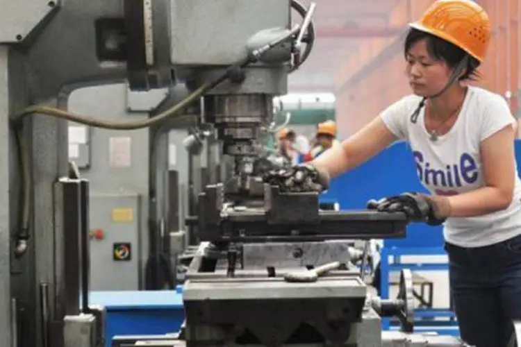 Chinesa trabalha em fábrica de Binzhou: a avaliação "mudou significativamente" para China e Índia e agora prevê uma desaceleração (AFP/Divulgação)