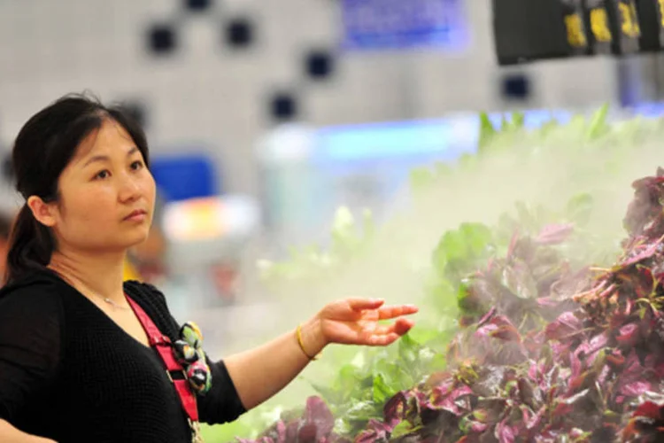 Mulher faz compras em supermercado em Jiujiang: principais líderes devem permitir que o crescimento fique em até 7% antes de adotarem novo estímulo para impulsionar a atividade (ChinaFotoPress/Getty Images)