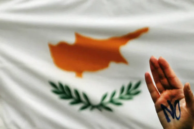 
	Bandeira do Chipre durante protesto:&nbsp;servi&ccedil;os que dever&atilde;o ser oferecidos a avia&ccedil;&atilde;o militar russa incluem pouso e estacionamento de aeronaves militares
 (REUTERS/Yannis Behrakis)