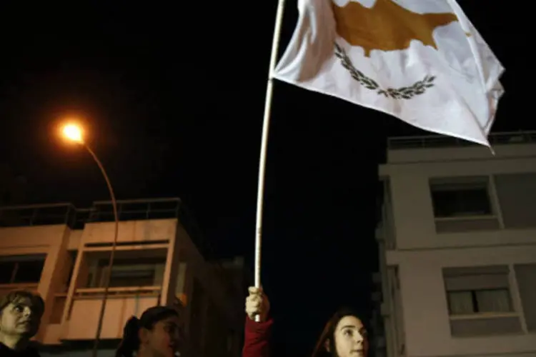 
	Manifestante carrega bandeira do Chipre: para arrecadar parte dos fundos necess&aacute;rios para o resgate do sistema financeiro, o governo anunciou a cria&ccedil;&atilde;o de um&nbsp;&quot;Fundo de Investimento Solid&aacute;rio&quot;
 (REUTERS/Yorgos Karahalis)