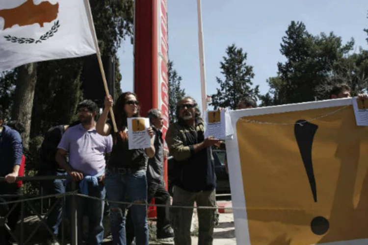 Manifestantes seguram bandeira do Chipre em protesto contra o plano de resgate do país, em Nicósia  (REUTERS / Yorgos Karahalis)