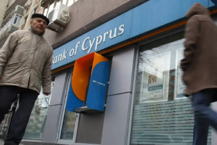 
	Pessoas caminham em frente a ag&ecirc;ncia do Banco do Chipre: o Banco Central lembrou que o Conselho do Banco Central Europeu (BCE) se comprometeu em proporcionar liquidez imediata ao Banco do Chipre.
 (REUTERS/Bogdan Cristel)