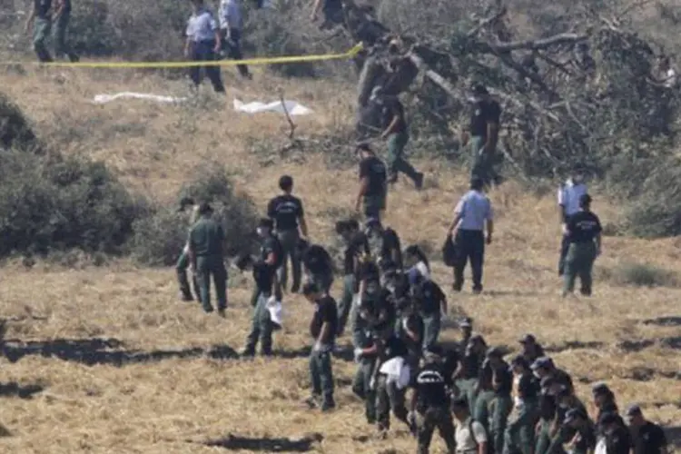 Policiais isolam parte da área onde ocorreram as explosões e cobrem com um lençol branco alguns dos corpos (ao fundo), ainda no local
 (Andreas Lazarou/AFP)