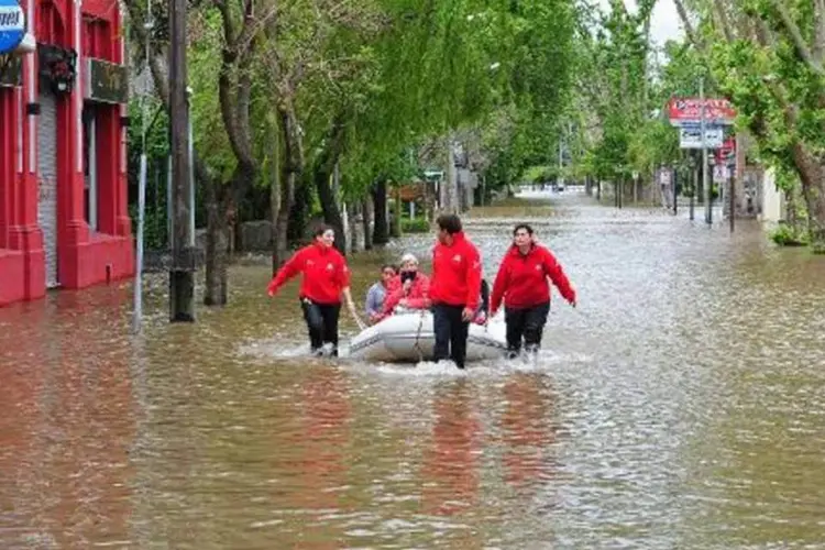 Bote carrega moradores de Tigre, na região metropolitana de Buenos Aires, durante inundações que atingiram boa parte da Argentina (STR/AFP)