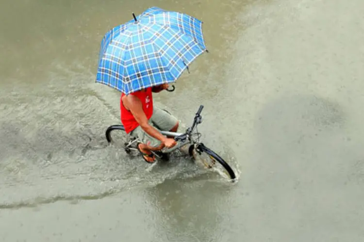 Pessoa de bicicleta na chuva: duas escolas municipais foram preparadas para funcionar como abrigo, caso haja necessidade de alojar desabrigados pelo temporal (Agliberto Lima/ Veja São Paulo)