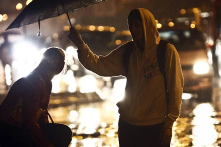 Casal se protege de chuva na Rússia: estrada que leva a alguns dos locais de eventos alpinos foi inundada por até 2,5 metros de água (Maxim Shemetov/Reuters)