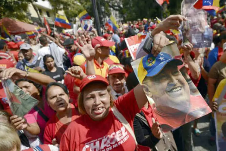 
	Simpatizantes de Ch&aacute;vez se re&uacute;nem na Pra&ccedil;a Simon Bolivar, em Caracas: &quot;Esta foi a maior b&ecirc;n&ccedil;&atilde;o de nosso Senhor Jesus Cristo&quot;, disse Herminia Martinez, de 67 anos
 (AFP/ Juan Barreto)