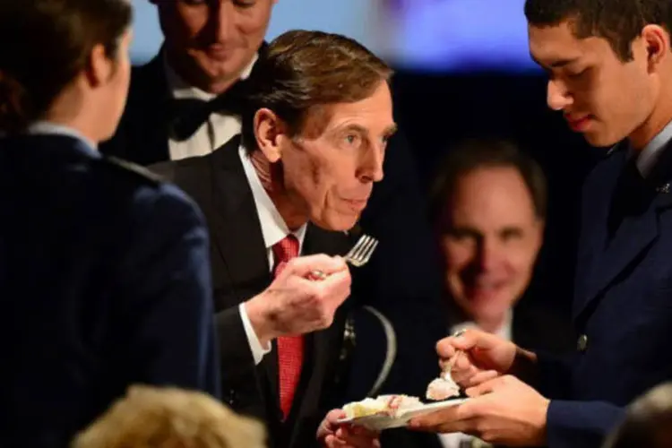 O ex-chefe da CIA David Petraeus come um pedaço de bolo antes de discurso em uma universidade, em 26 de março de 2013 (AFP / Frederic J. Brown)