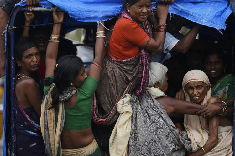 Indianos retornam a suas vilas depois da passagem do Ciclone Phailin pela cidade de Girisola, no distrito de Ganjam (REUTERS/Adnan Abidi)