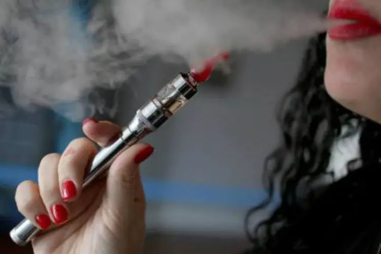 Mulher fuma cigarro eletrônico: transição do tabaco para o vapor é um fenômeno crescente (Joe Raedle/AFP)