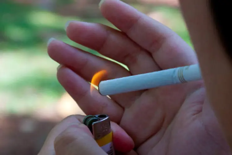 
	Fumante acendendo cigarro: a parcela de brasileiros com mais de 18 anos que fumam caiu de 15,7% em 2006 para 11,3% em 2013
 (Marcos Santos/USP Imagens)