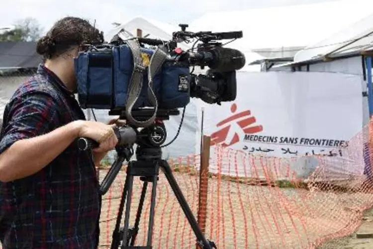 Cinegrafista filma entrada do centro de tratamento do ebola da ONG Médicos Sem Fronteiras (Pascal Guyot/AFP)