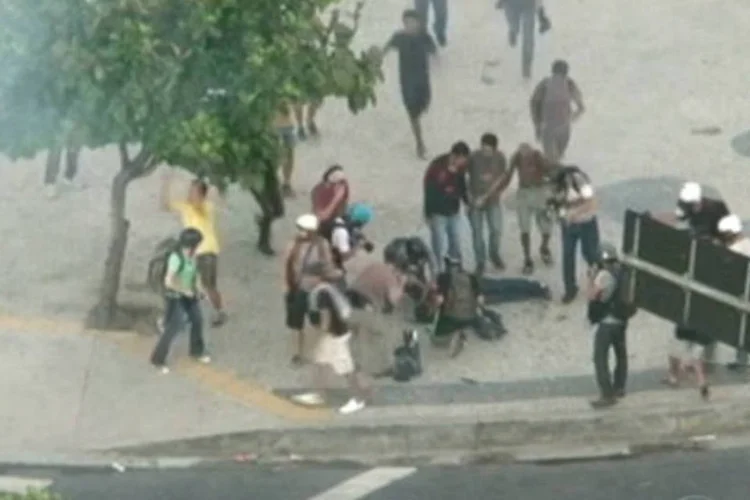 
	Pessoas socorrem cinegrafista da TV Bandeirantes ap&oacute;s ser atingido por artefato:&nbsp;Caio Silva de Souza foi preso em uma pousada em Feira de Santana (BA)
 (Reprodução/TV Globo)