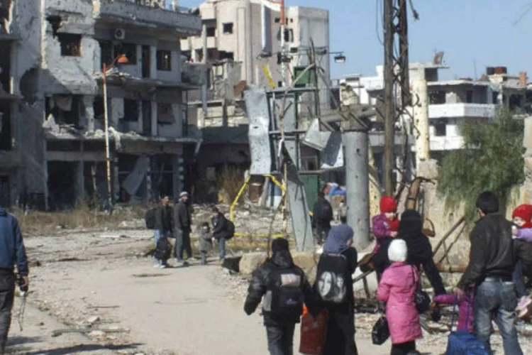 
	Civis durante evacua&ccedil;&atilde;o de Homs, na S&iacute;ria:&nbsp;autoridades acomodaram em alojamentos tempor&aacute;rios 143 pessoas
 (Yazan Homsy/Reuters)