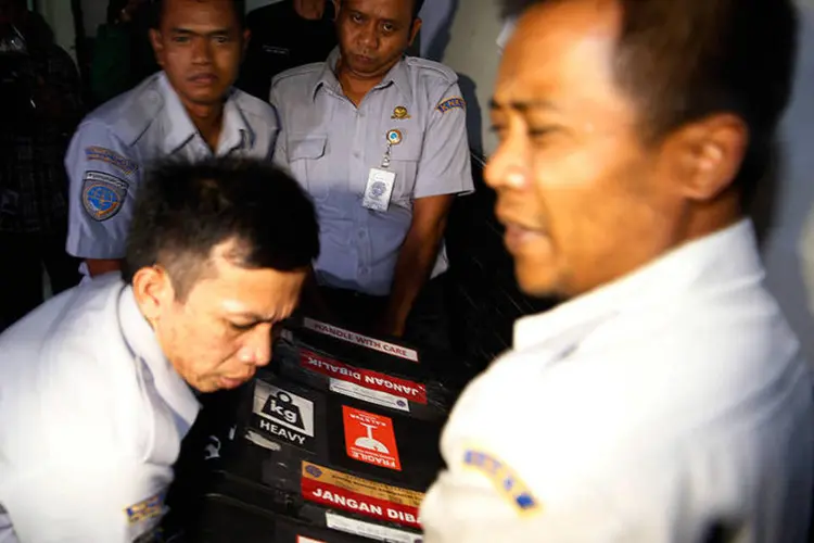 Oficiais carregam 1ª caixa-preta do avião acidentado da AirAsia: será preciso uma inspeção cuidadosa para certificar que ela não sofreu danos significativos (REUTERS/Beawiharta)