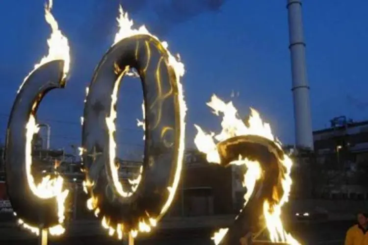 Ativistas do Greenpeace queimam símbolo químico do dióxido de carbono, em protesto na usina geradora de energia em Klingenberg, em Berlim (AFP/Arquivo / Theo Heimann)