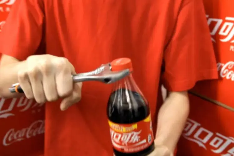 Funcionário da Coca-Cola apertando tampinhas das garrafas da marca em vídeo da ação "Icebreaker" (Reprodução)