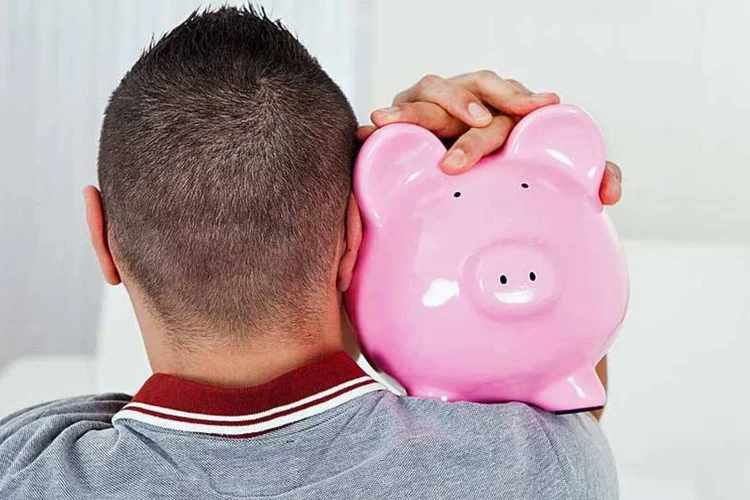 
	Homem abra&ccedil;ado a cofre em formato de porco: dos 69,5% dos brasileiros que aplicam na caderneta, 56,1% o fazem para evitar riscos
 (AndreyPopov/Thinkstock)