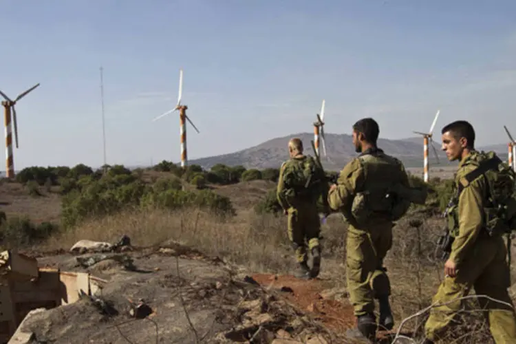 
	Soldados israelenses cominham em frente a turbinas de vento nas Colinas de Gol&atilde;, fronteira entre S&iacute;ria e Israel
 (Nir Elias/Reuters)