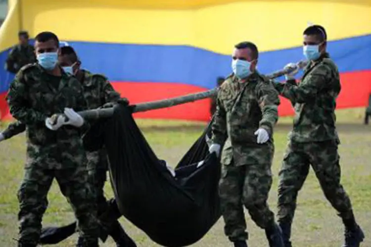 Soldados colombianos carregam corpos de membros das FARC, em Tame, em 10 de janeiro de 2014 (Eitan Abramovich/AFP)