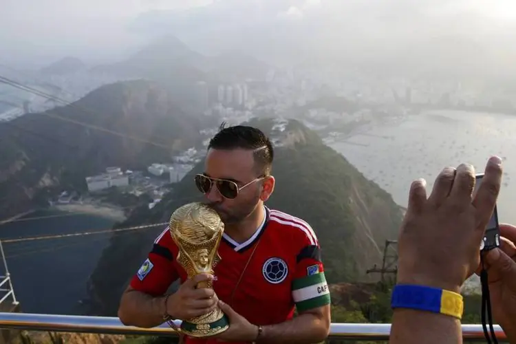Torcedor colombiano tira uma foto com uma réplica da taça da Copa do Mundo, no Rio de Janeiro (Paul Hanna/Reuters)