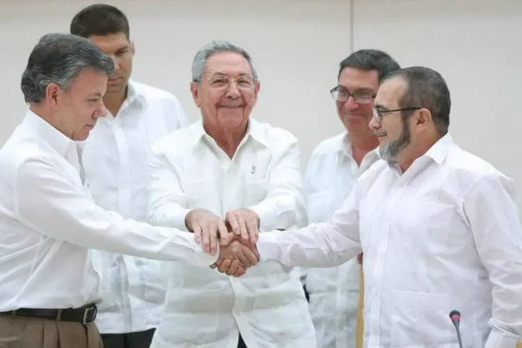 
	Presidente colombiano (E) cumprimenta l&iacute;der das Farc em Havana: plano ter&aacute; &quot;origem constitucional&quot; e ser&aacute; desenvolvido mediante &quot;uma lei de car&aacute;ter especial&quot; que ter&aacute; &quot;uma vig&ecirc;ncia m&iacute;nima de dez anos&quot;
 (Alexandre Meneghini/Reuters)