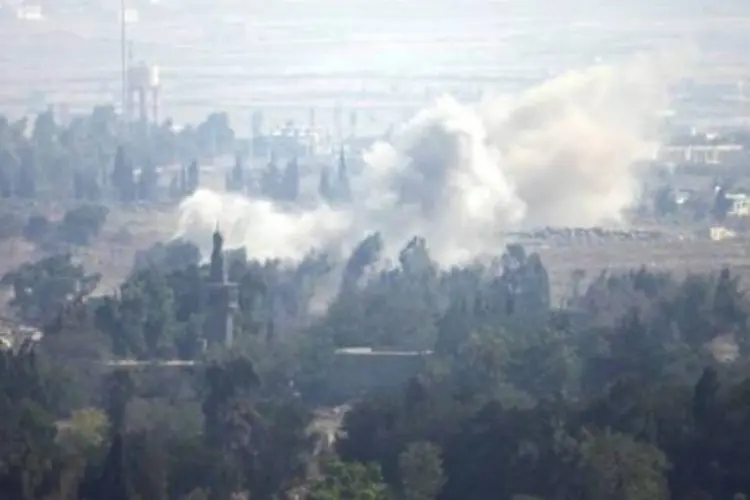 
	Cidade s&iacute;ria de Quneitra atingida por bombardeios, em foto tirada a partir das Colinas de Gol&atilde;
 (Jalaa Marey/AFP)