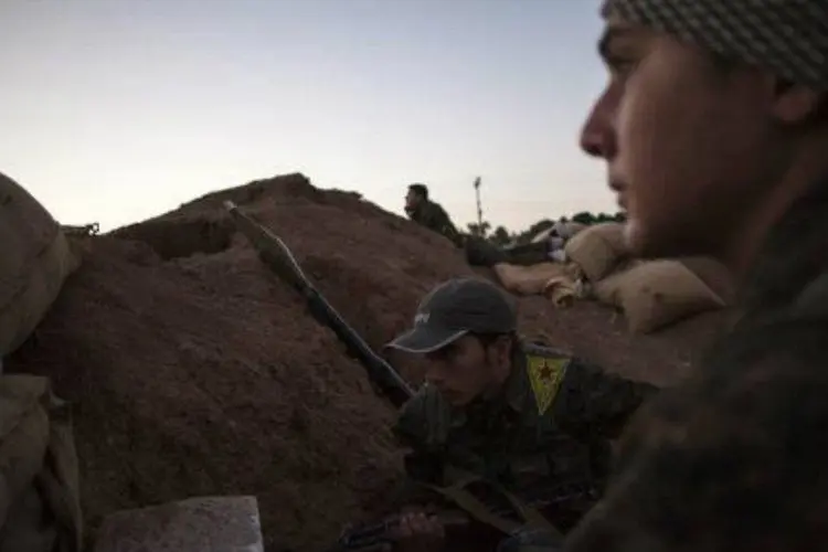 Combatentes curdos em um posto de controle perto da cidade síria de Ras al-Ain, que foi cenário de grandes combates em 2013, antes que as forças curdas conseguissem expulsar os jihadistas da cidade (AFP/ Fabio Bucciarelli)