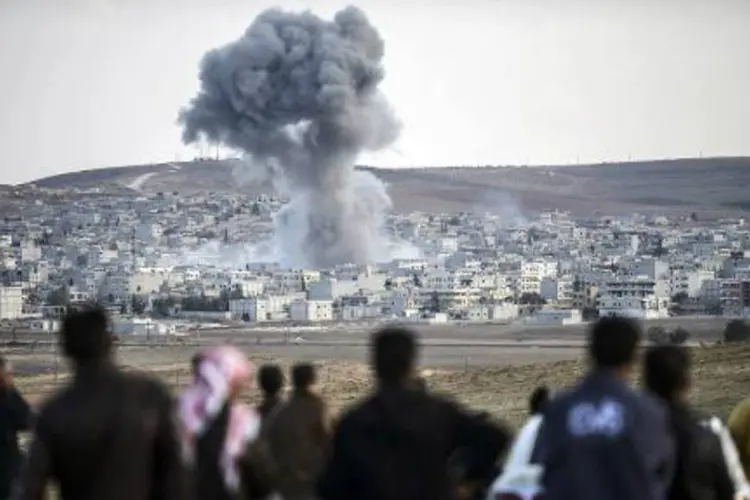 
	Curdos observam na cidade turca de Mursitpinar a fuma&ccedil;a provocada pelos combates na cidade s&iacute;ria de Kobani
 (AFP)
