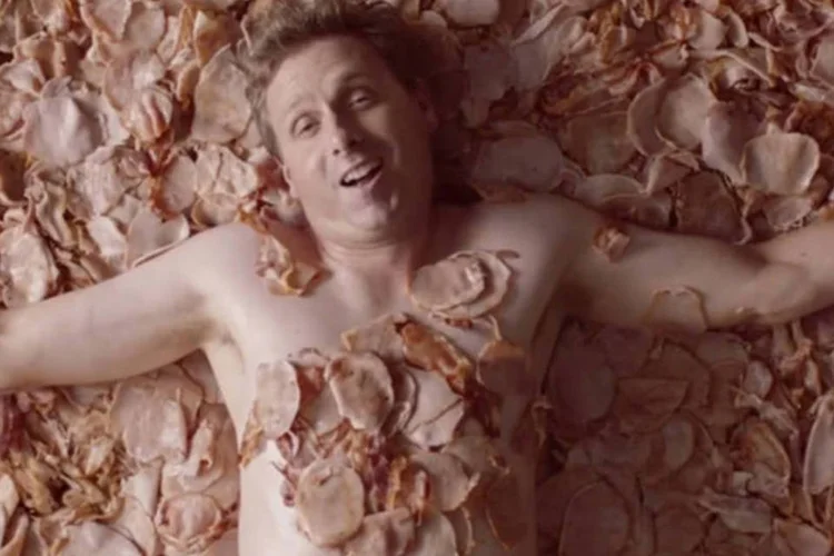Comercial de bacon: pétalas são substituídas por pedaços de bacon, e em vez de uma garota, o “sonhador” imagina a si próprio coberto pela carne (Reprodução/YouTube)