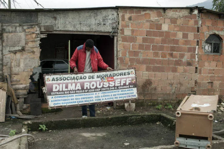 Morador de comunidade mostra placa de homenagem à Dilma: "acabou a associação. Acabou. Acabou Dilma Rousseff”, diz líder da comunidade (Eduardo Zappia/Bloomberg)