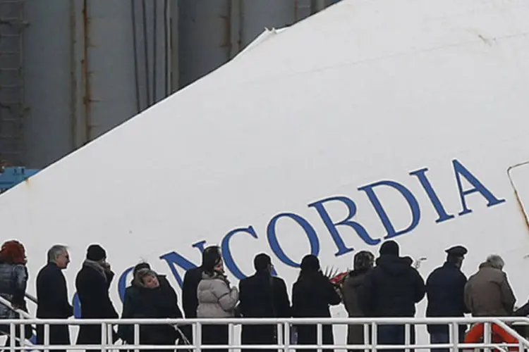 Parentes de vítimas em ferry que as levou ao local onde navio Costa Concordia está encalhado, na Ilha de Giglio, na Itália (REUTERS/Tony Gentile)