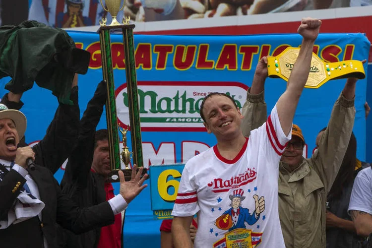 Joey Chestnut comemora após vencer o concurso de cachorro-quente, nos EUA (Eric Thayer/Reuters)