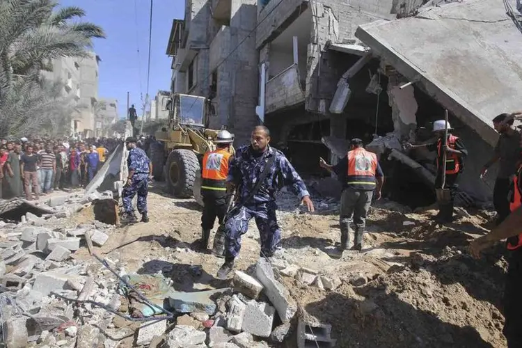 Policiais palestinos no local de um bombardeio da Força Aérea de Israel, na Faixa de Gaza (Ibraheem Abu Mustafa/Reuters)