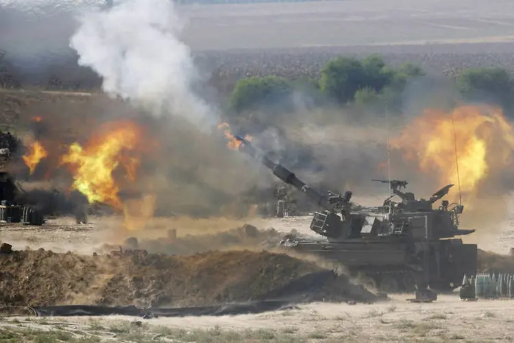 Uma unidade de artilharia móvel israelense dispara contra a Faixa de Gaza nesta segunda-feira (Baz Ratner/Reuters)
