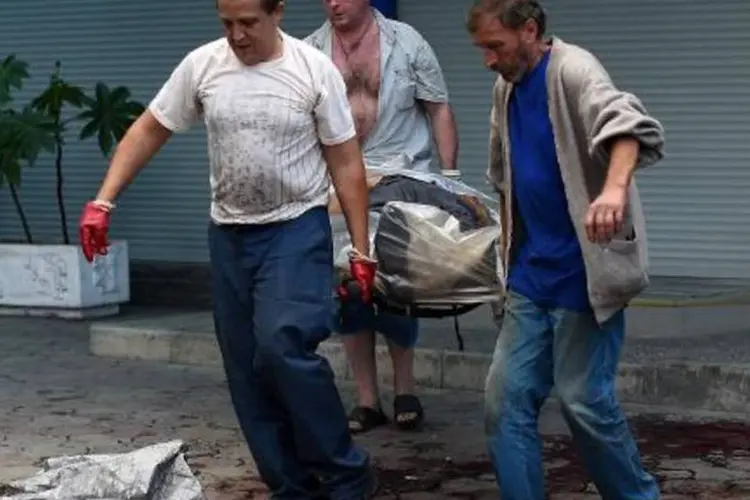 Corpo de uma das vítimas civis do conflito na Ucrânia é removido de rua em Donetsk (Francisco Leong/AFP)