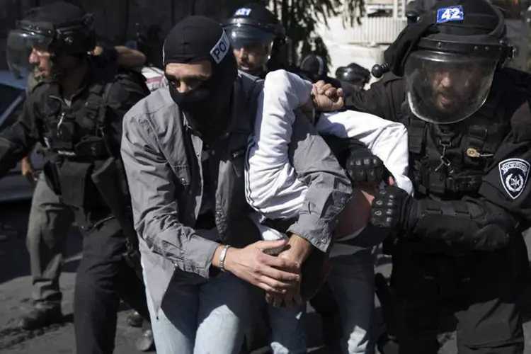 Policiais israelenses prendem um pelestino após confrontos no leste de Jerusalém (Finbarr OReilly/Reuters)